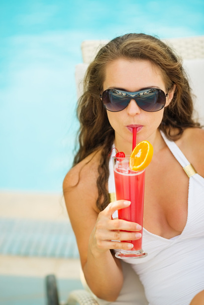 Young woman relaxing in pool with cocktail - Fotoğraf, Görsel