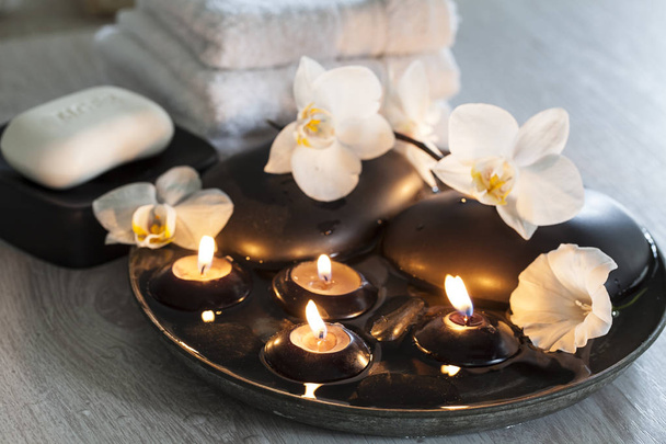 Decorative spa still life with soap, towels, orchid flowers and candles - Photo, image