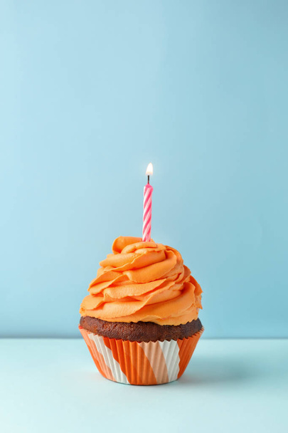 Delicious birthday cupcake with candle on color background - Foto, Imagem