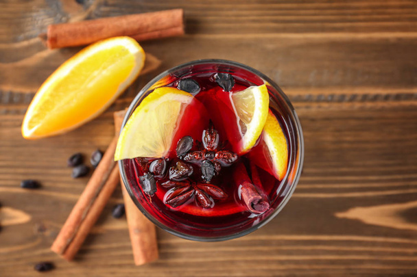 Glass of delicious mulled wine on wooden table - Photo, Image