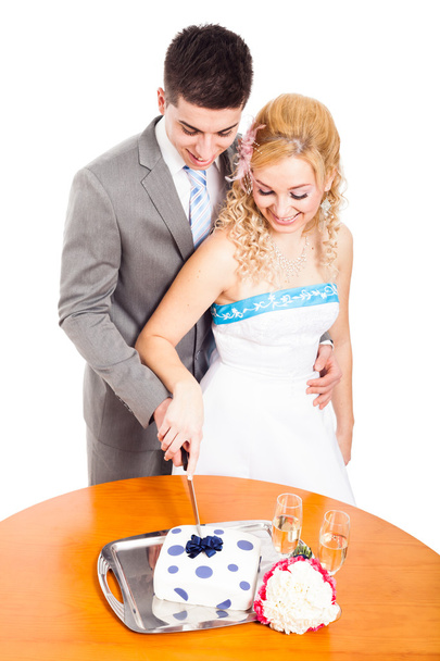 Pareja joven cortando pastel de boda
 - Foto, Imagen