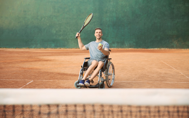 Νεαρός σε αναπηρική καρέκλα παίζοντας τένις στο γήπεδο - Φωτογραφία, εικόνα
