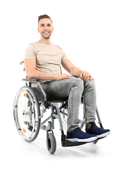 Young man sitting in wheelchair on white background - Fotó, kép
