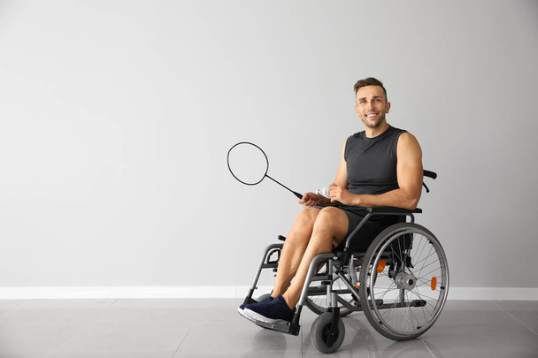 Μπάντμιντον παίκτη που κάθεται σε αναπηρικό καρότσι φως τοίχο - Φωτογραφία, εικόνα