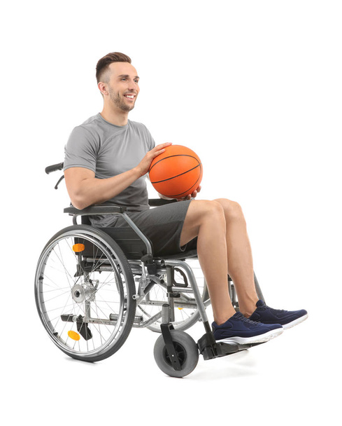 Jonge basketbalspeler, zittend in de rolstoel op witte achtergrond - Foto, afbeelding