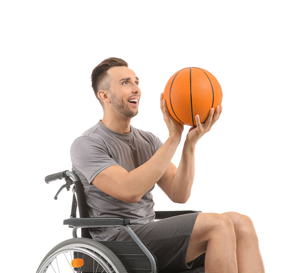 Giovane giocatore di basket seduto in sedia a rotelle su sfondo bianco
 - Foto, immagini