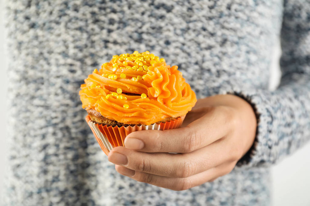 Donna che tiene gustoso cupcake con spruzzi, primo piano
 - Foto, immagini