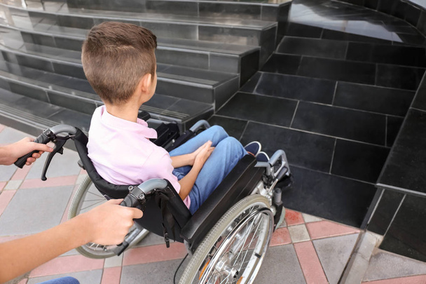 Genç kız ve erkek kardeşi tekerlekli sandalyeye mahkum merdiven açık havada yakınındaki - Fotoğraf, Görsel
