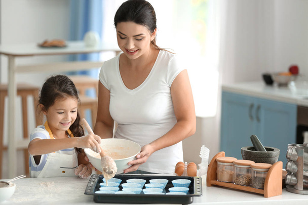 Mother and daughter cooking together in kitchen - Photo, Image