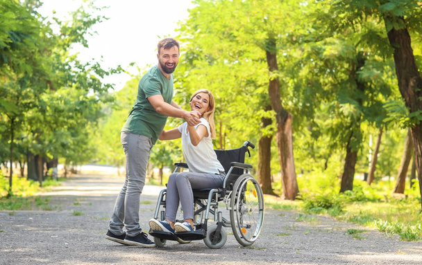 Piękna kobieta na wózku inwalidzkim z mężczyzną, taniec na zewnątrz - Zdjęcie, obraz