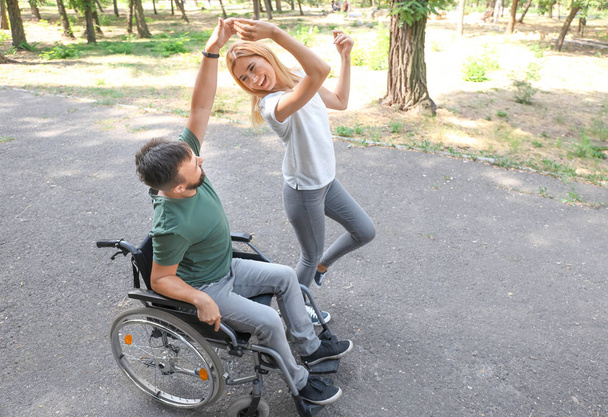 Muž na vozíku s krásné ženy tančí venku - Fotografie, Obrázek
