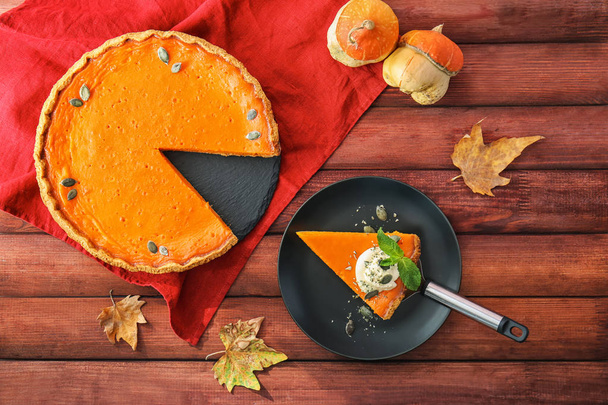 Flat lay composition with tasty pumpkin pie on wooden table - Photo, Image