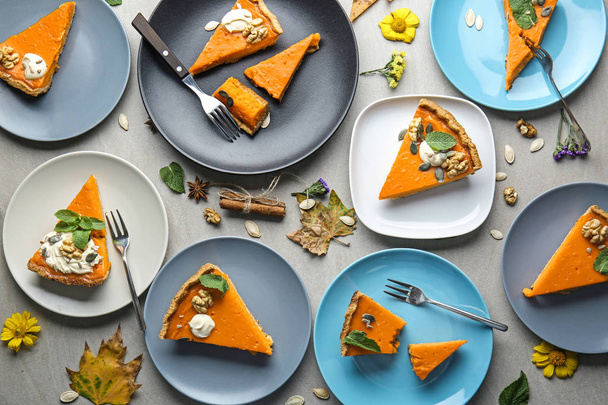 Plates with pieces of tasty pumpkin pie on table, top view - Photo, Image