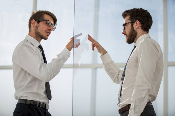 two businessmen on both sides of a glass Board - Фото, изображение
