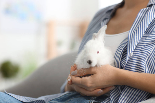 Beautiful young woman with cute rabbit at home, closeup - Photo, Image