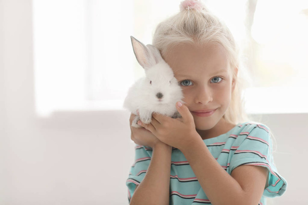 Menina com coelho bonito em casa
 - Foto, Imagem