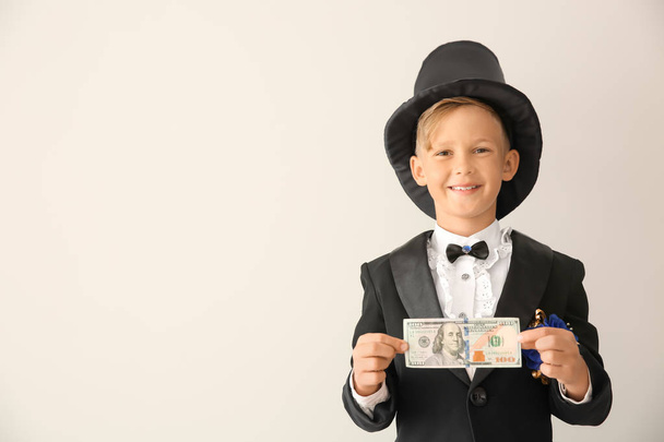Roztomilý malý kouzelník zobrazeno trik s penězi na bílém pozadí - Fotografie, Obrázek