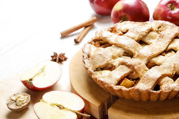 Traditional American Thanks Giving pie, whole & halved apples, cinnamon sticks, anise seeds. Homemade fruit tart baked to golden crust with ingredients. Close up, copy space, top view, background. - 写真・画像