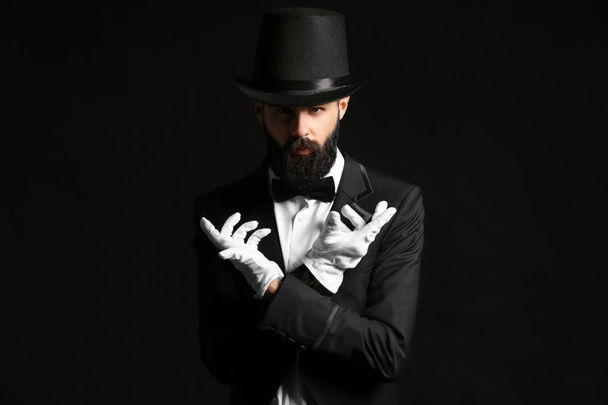 Male magician on dark background - 写真・画像