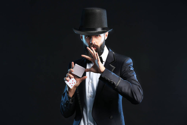 Zauberer zeigt Tricks mit Karten auf dunklem Hintergrund - Foto, Bild