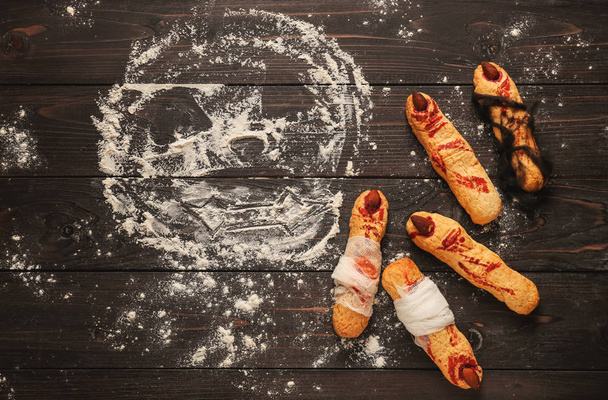 Мука с креативным печеньем, приготовленная для Хэллоуина на деревянном столе
 - Фото, изображение