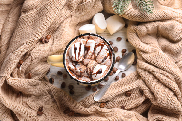 Metal cup of hot chocolate with marshmallows and warm plaid on table - Photo, Image