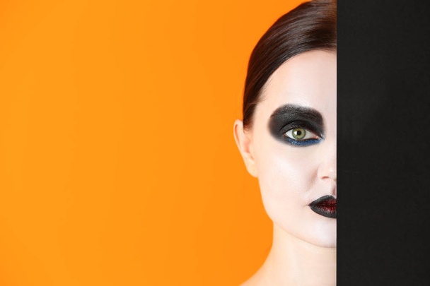 Beautiful woman with Halloween makeup and poster on color background - Photo, Image