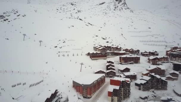 Drohnen-Kamera zeigt modernes, kleines, schneebedecktes Skigebiet umgeben von Hügeln - Filmmaterial, Video
