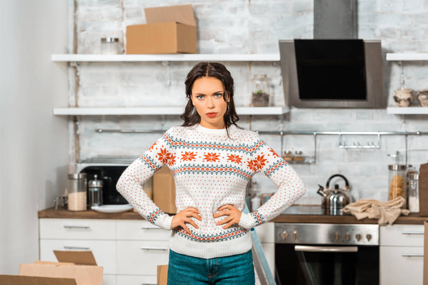 aggressiva giovane donna in piedi con le mani in vita in cucina a nuova casa
  - Foto, immagini