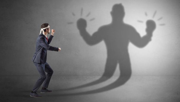 Бизнесмен борется со своей безоружной тенью
 - Фото, изображение