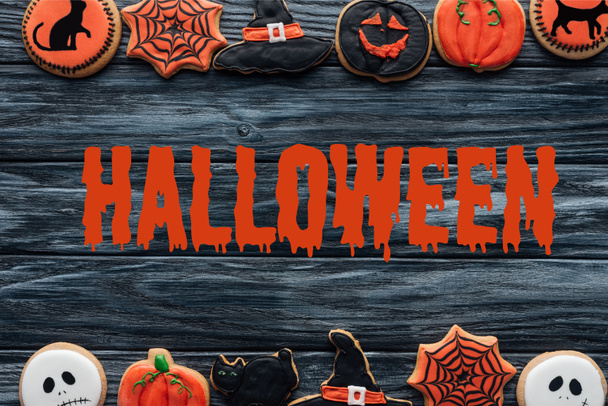 top view of arranged homemade cookies placed in rows on wooden background  with "halloween" lettering - Photo, image