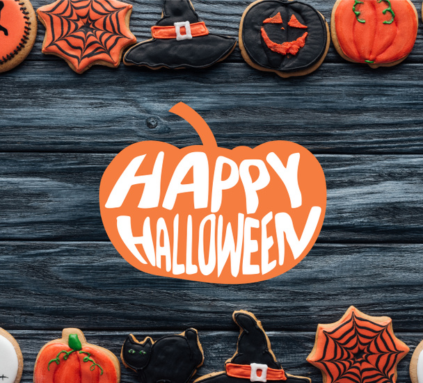 vue du dessus des biscuits faits maison disposés halloween placés en rangées sur fond en bois avec des lettres de citrouille et "happy halloween"
 - Photo, image