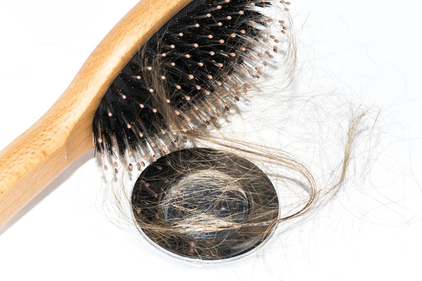 Hair loss on washbasin. Long brown hair with wood brush on white basin in the bathroom. Healthcare concept - Φωτογραφία, εικόνα