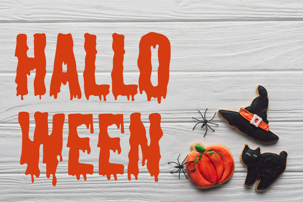 elevated view of tasty homemade halloween cookies on wooden background  with "halloween" lettering - Valokuva, kuva