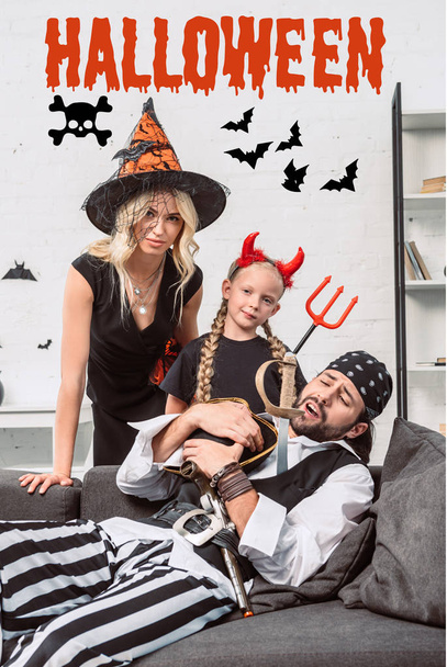 portrait of family in halloween costumes at home with "halloween" lettering - Photo, Image