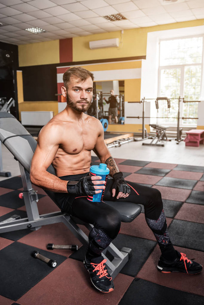 young sportsman resting after training with protein coktail - Foto, afbeelding