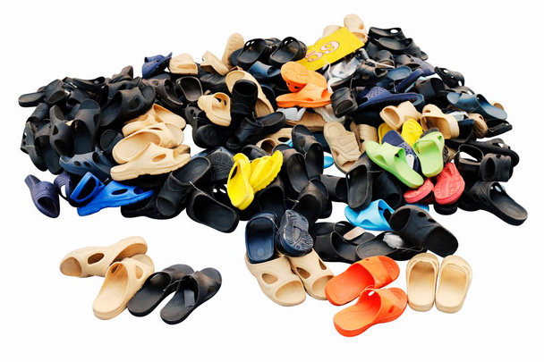 Кучи обуви продаются в различных цветовых комбинациях сельский рынок земли, сандалии, повседневная обувь, старый. изолированные на белом фоне
 - Фото, изображение