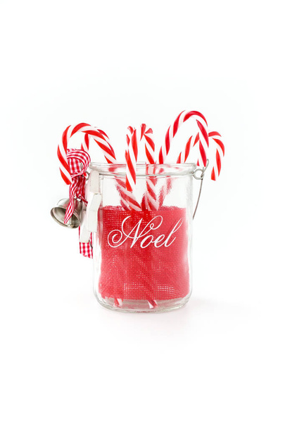Barattolo di vetro di Natale decorato con scrittura Noel riempito con bastoncini di zucchero. Fatto in casa, fai da te
. - Foto, immagini