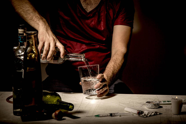 Young man , lost in the vices of alcoholism, smoking and drug addiction - 写真・画像