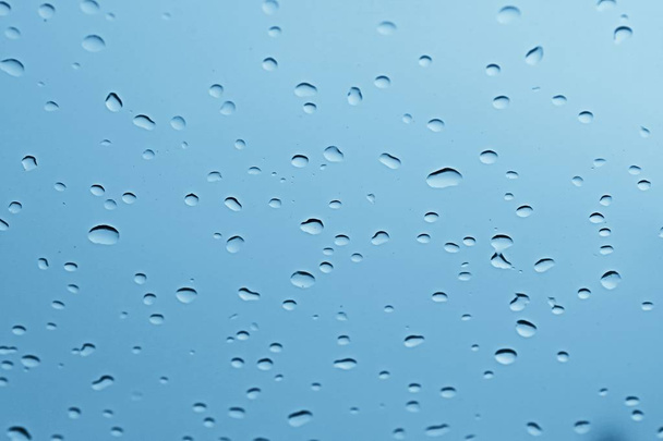 νερό βροχής σταγόνα στο μπλε γυαλί για αφηρημένη φρέσκα φόντο - Φωτογραφία, εικόνα