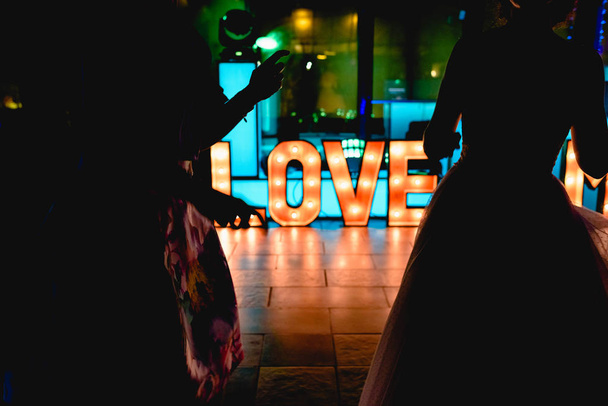 Lettere di legno luminose con parola Amore in una festa
 - Foto, immagini