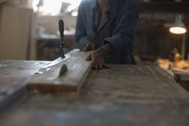Handmade concept. Hobby. A woman is sawing a wooden board on a saw in the workshop - Foto, Imagem