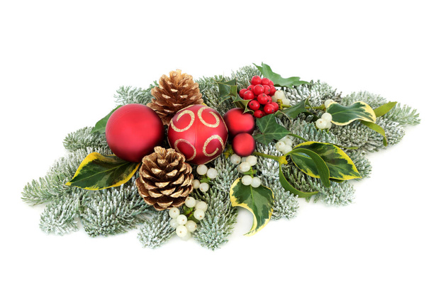 Décoration de table de Noël et d'hiver avec décorations en boules, baies de houx, pin d'épinette recouvert de neige, gui, lierre et cônes de pin sur fond blanc
. - Photo, image
