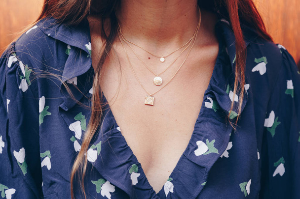 fashion blogger outfit details. modieuze vrouw draagt een gouden ketting ketting. detail van een perfecte val fashion outfit. - Foto, afbeelding