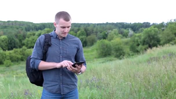 Man in a field with digital tablet - Кадри, відео