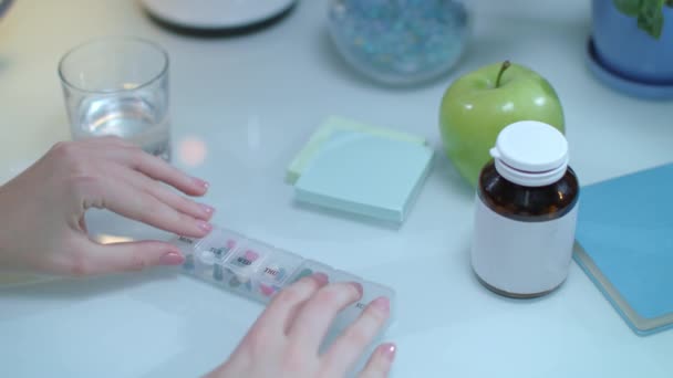 Vrouw Neem dagelijkse capsule uit pil dispenser. Vrouw hand nemen capsule pil vak - Video