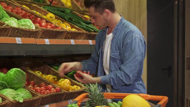 Guy buys fruits and vegetables at the hypermarket - Foto, immagini