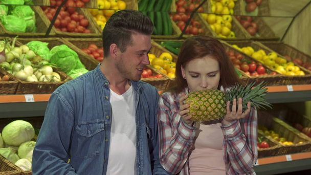 Couple buys pineapple at the supermarket - Photo, Image