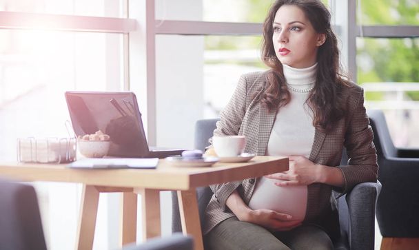 Беременная женщина работает за компьютером в кафе
 - Фото, изображение