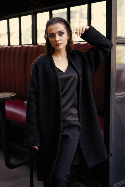 Gorgeous young brunette woman in black clothes posing  - Fotografie, Obrázek